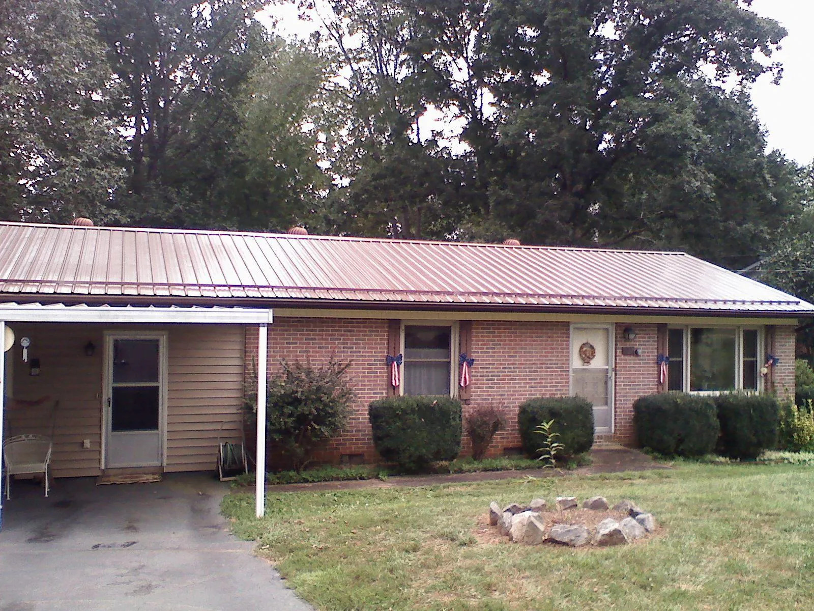 Bronze metal roof and carport on a brick ranch home — Roof Repair work by our crew in Mexia