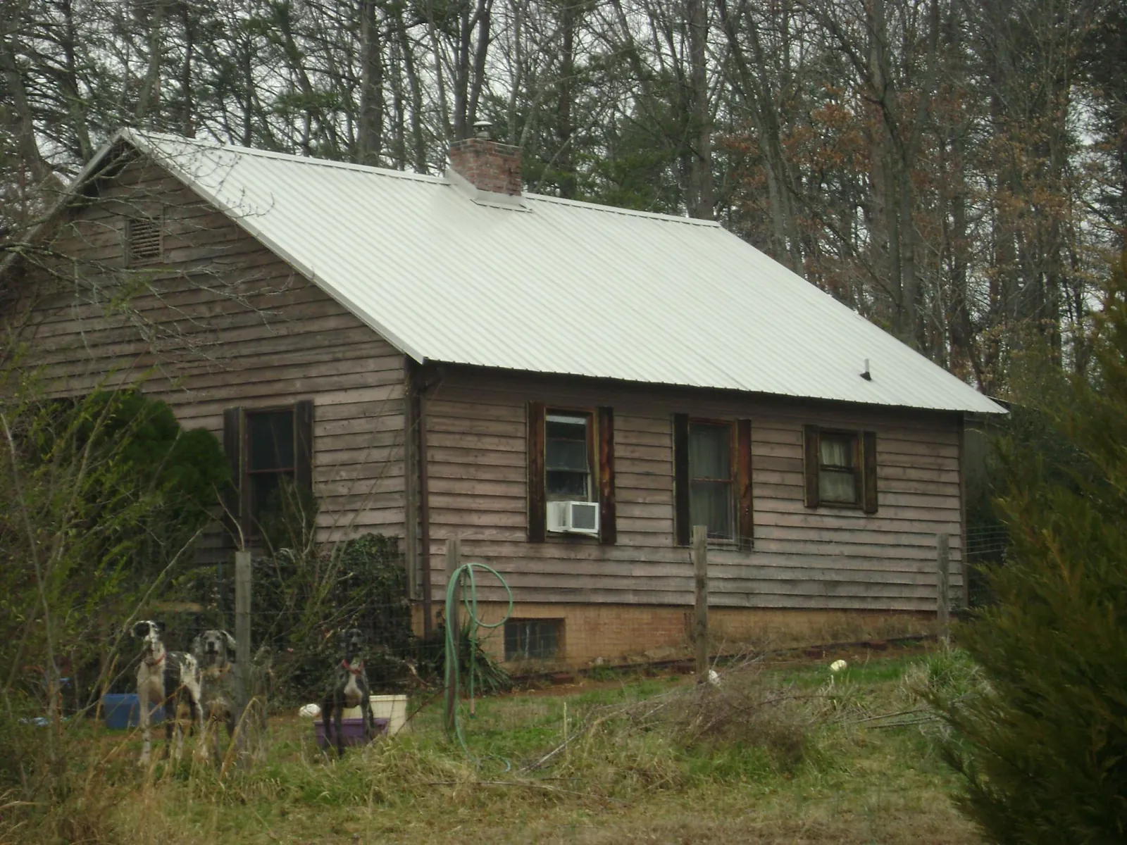 White metal roof on an old wood sided farmhouse, from a Metal Roof Installation job in Mexia